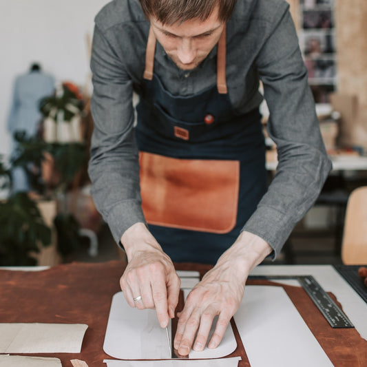 Man working on leather craft cutting patterns